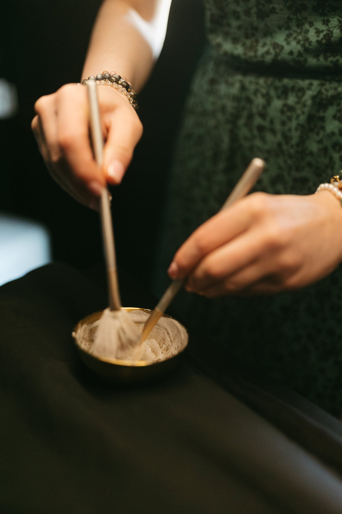 Hands mixing skincare in a bowl with brushes at the skin sanctum in Denver co